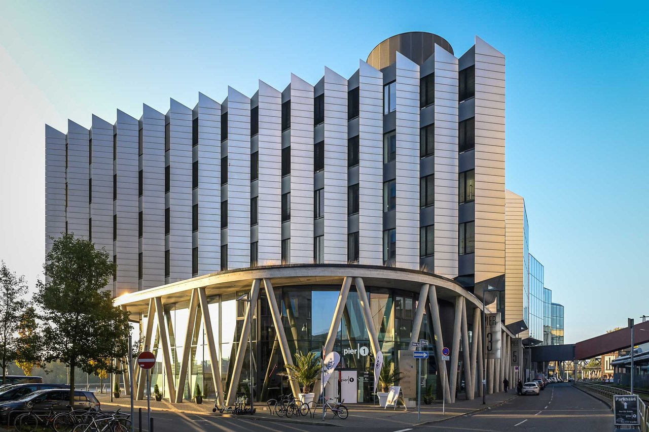Modernes Bürogebäude mit Lamellenfassade bei Sonnenuntergang